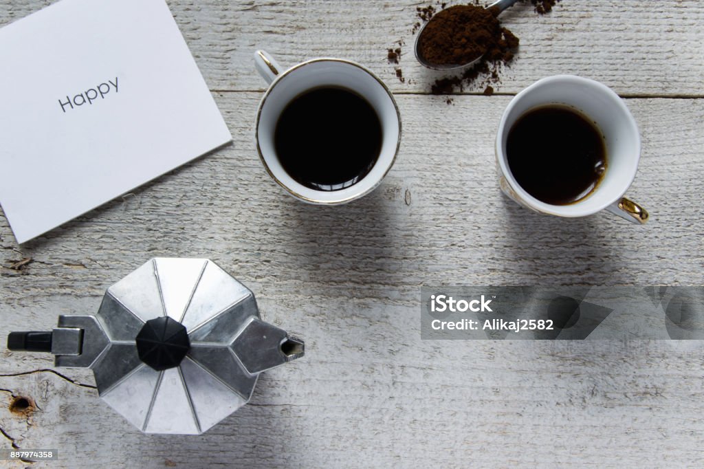 Happy coffee time. Top view of two coffee cups, italian coffee maker-moka and white card with "Happy" text Albania Stock Photo