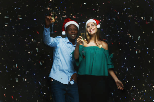 istock Joyful couple congratulating on christmas with champagne at blac 887974804