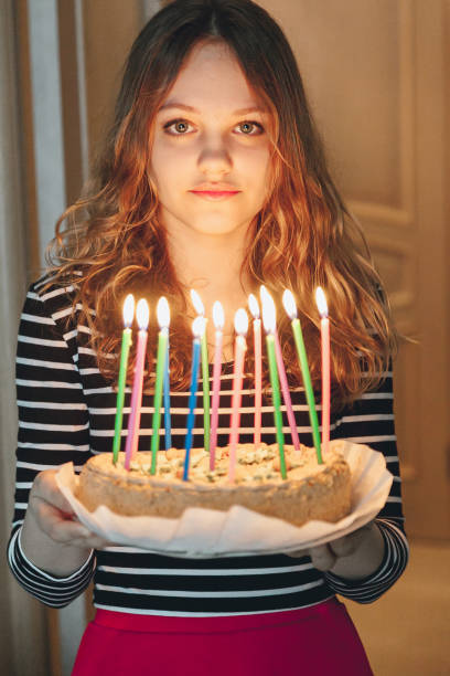 istock Young beautiful girl holding cake with burning candles 887977146