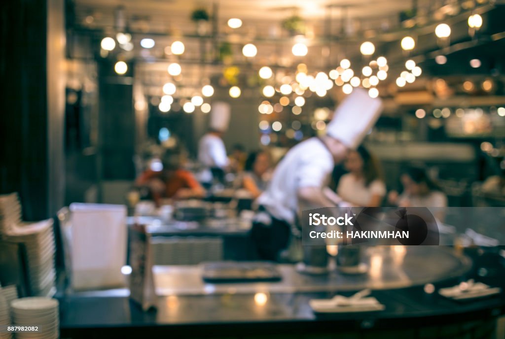 Blur chef cooking in restaurant with  customer Blur chef cooking in restaurant with  customer sitting Restaurant Stock Photo
