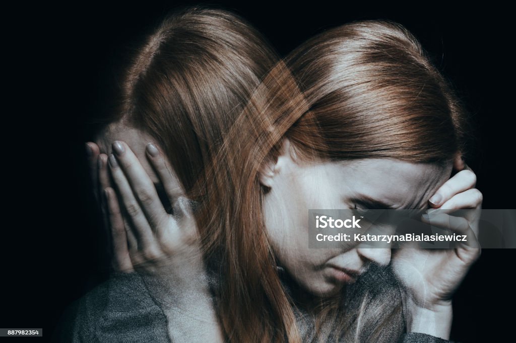Female with mood disorder Young red haired female with mood disorder crying and having a headache Depression - Sadness Stock Photo