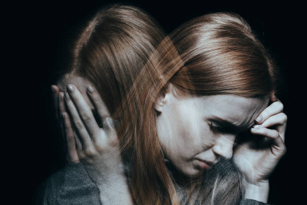 Female with mood disorder Young red haired female with mood disorder crying and having a headache schizophrenia photos stock pictures, royalty-free photos & images