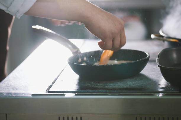 istock chef is frying meat and vegetables in a pan 887982886