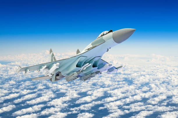 istock Military fighter jet plane above the clouds. 887987006