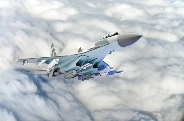 istock Military fighter jet plane above the clouds. 887987010