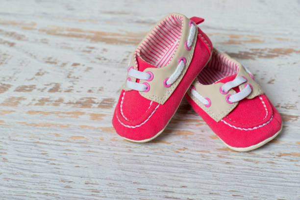 istock Baby red shoes on a rope against a white brick wall 888001302
