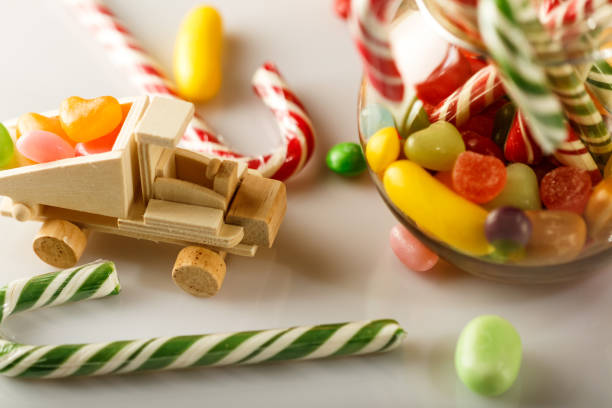 Festive mess on the table. toys and candy. White glossy table. The candy jar.