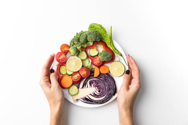 istock woman holding plate with salad 888033540