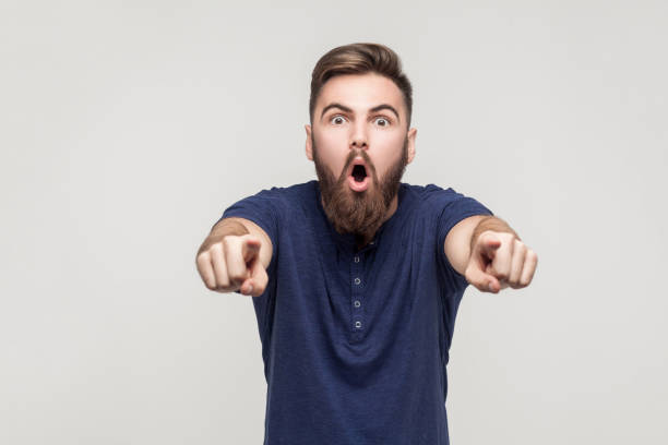 Hey you! Amazement bearded man pointing fingers at camera Hey you! Amazement bearded man pointing fingers at camera with open mouth and big eyes. Studio shot angry hairstylist stock pictures, royalty-free photos & images