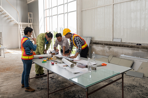 Engineer group asia and worker meeting, discussion with construction on site work in friendly atmosphere joking and having fun during working process