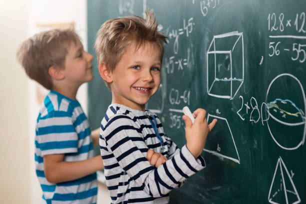 la matematica è divertente - i ragazzi in piedi alla lavagna - simplicity mathematics mathematical symbol blackboard foto e immagini stock