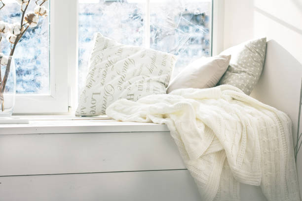 istock cushions and a knitted plaid on the windowsill. 888040018