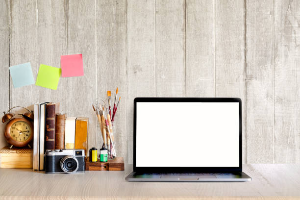 istock Mock up Laptop : Work space desktop with blank white screen laptop, vintage camera, pencils and stationery items. Blank screen for graphics display montage. 888045340