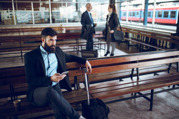 istock Businessman using mobile phone at train station 888048890