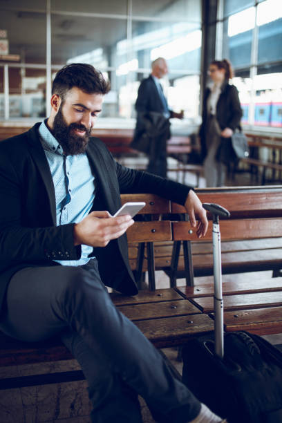 istock Businessman using mobile phone at train station 888049506