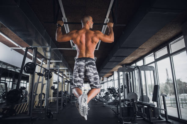 Athlete doing pull-up on horizontal bar Athlete doing pull-up on horizontal bar. chin ups photos stock pictures, royalty-free photos & images
