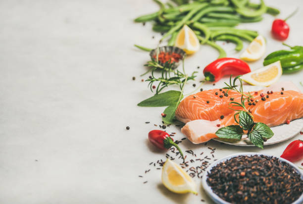 Raw salmon steaks with vegetables, greens and rice, copy space