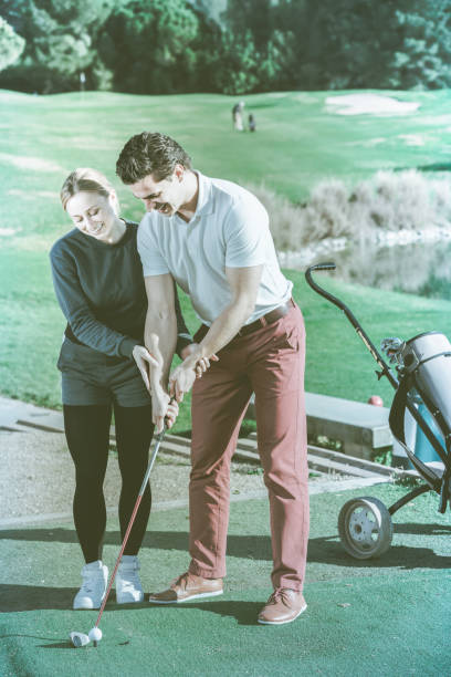 istock Female golf player  shows man  the correct hand position 888063528