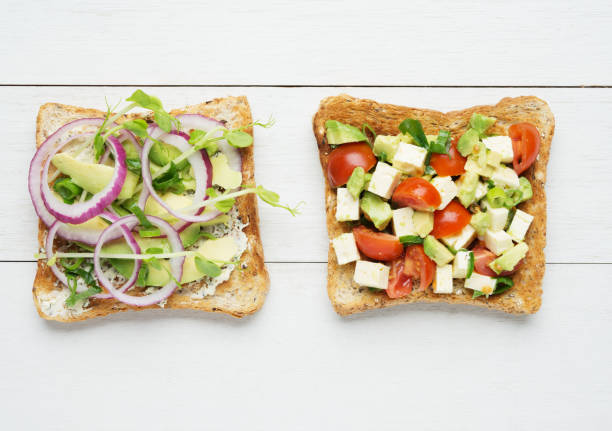 istock Two avocado toasts on white wooden background 888063760