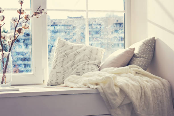istock cushions and a knitted plaid on the windowsill. 888063982