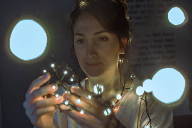 istock Young woman with christmas lights 888066428
