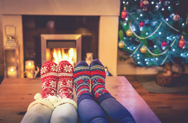 istock Feet in wool socks near fireplace in Christmas time 888083268
