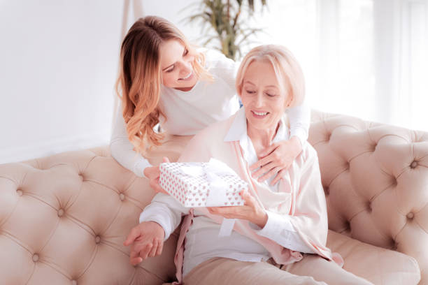 istock Happy young woman giving a present to her mom 888094516