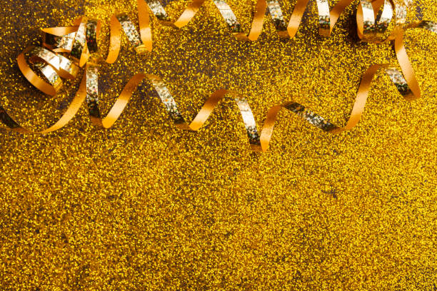 istock Curly golden serpentine on glitter background 888094628
