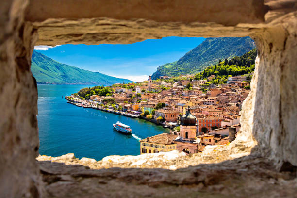 Limone sul Garda view through stone window from hill, Garda lake in Lombardy region of Italy Limone sul Garda view through stone window from hill, Garda lake in Lombardy region of Italy italian lake district photos stock pictures, royalty-free photos & images