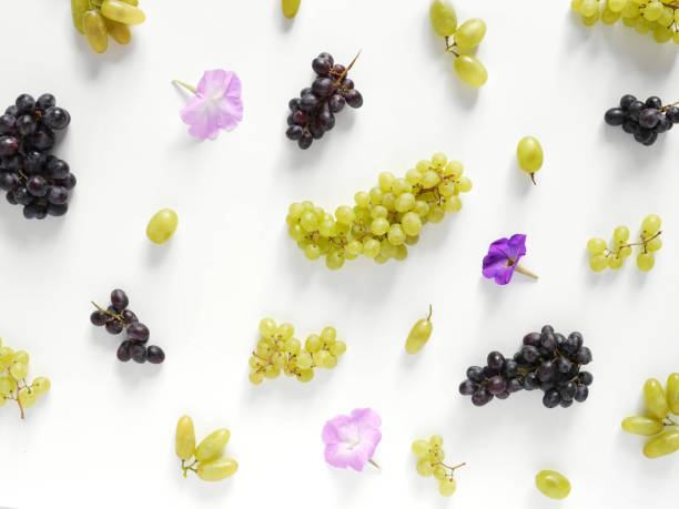 istock Black and green grapes, lilac flowers on a white background. 888112606