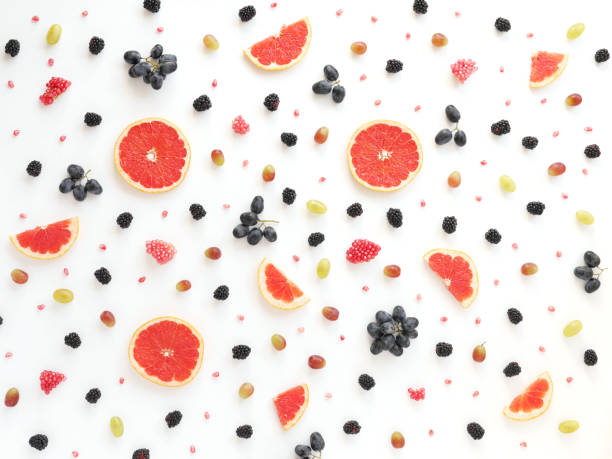 Concept of healthy food. Berries and fruit pattern. Concept of healthy food. Berries and fruit pattern. Slices of grapefruit, blackberries, grains of pomegranate, black and green grapes on a white background.Composition of berries and fruits, top view. food styling stock pictures, royalty-free photos & images