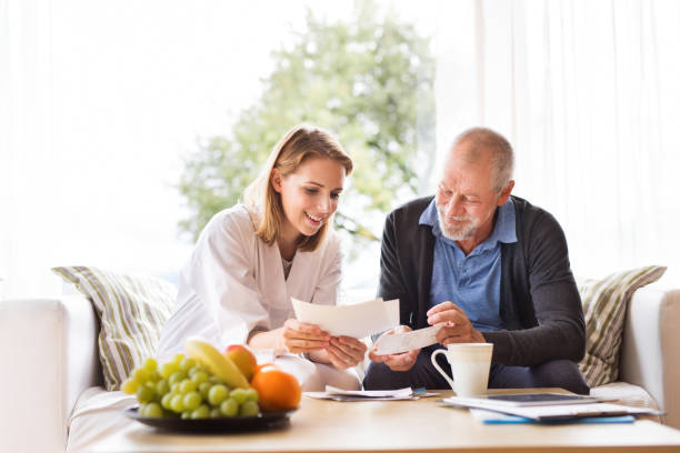 istock Health visitor and a senior man with tablet during home visit. 888114088