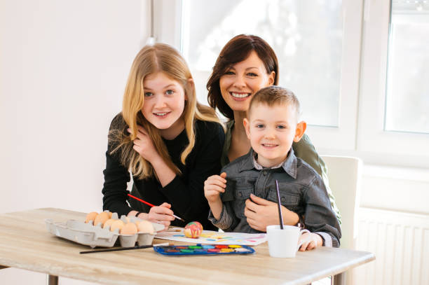 istock A mother and her children painting Easter eggs. 888116870