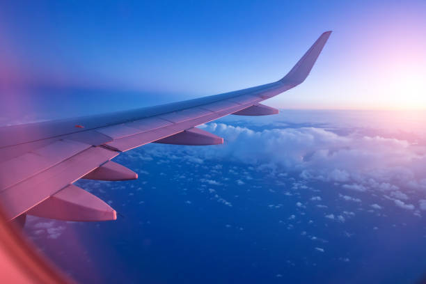 istock View from passenger's seat in airplane flying above clouds in dramatic sunset light. 888119976