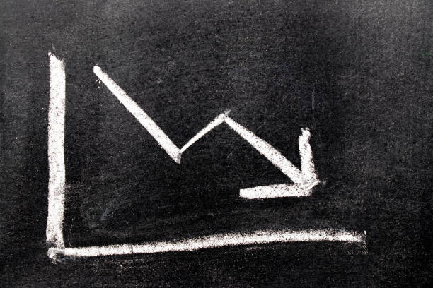 istock White color hand drawing chalk in arrow down shape on black board background (Concept of stock decline, down trend of business, economy) 888121150