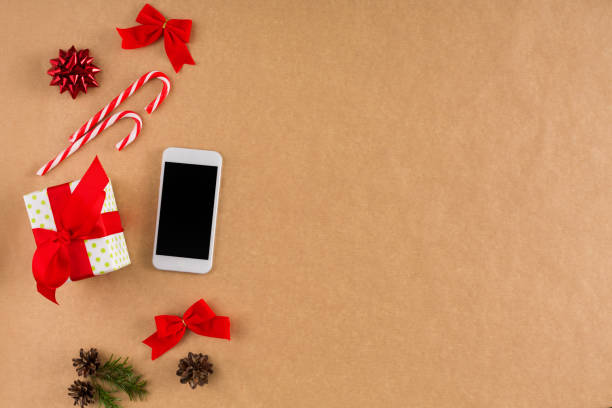 istock Phone and Christmas decorations on craft paper background, top view, flat lay. 888123798