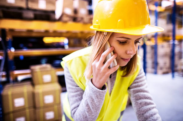 istock Female warehouse worker with smartphone. 888145968