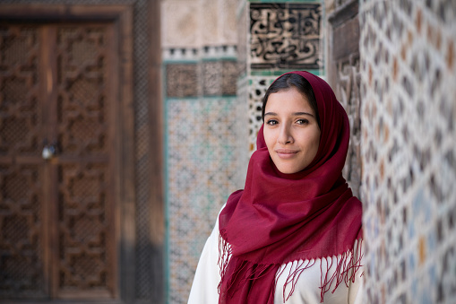 Arab woman in traditional clothing with red hijab on her head