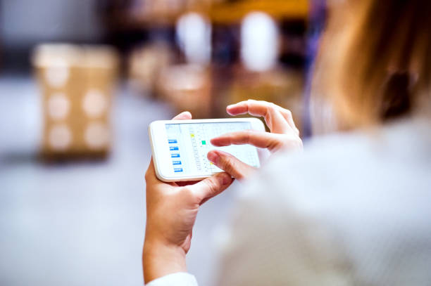 istock Woman warehouse worker with smartphone. 888146902