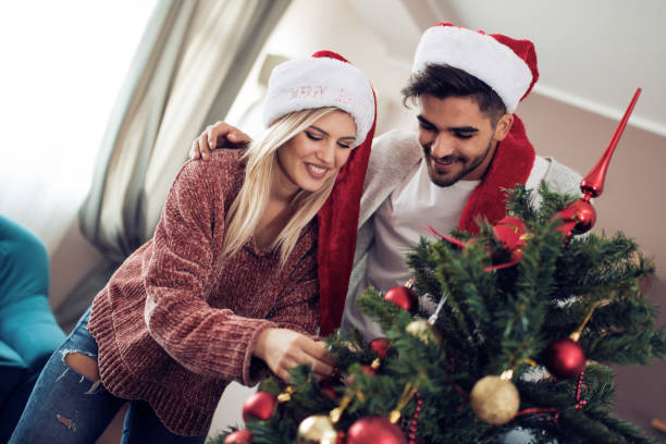 istock Happy couple decorating Christmas tree in their home 888146954