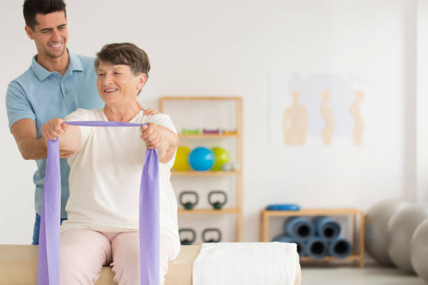 Smiling physiotherapist helping older woman