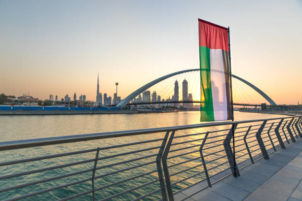 Dubai Downtown skyline at sunrise. Dubai Downtown skyline with UAE national flag over the water canal at sunrise. Dubai, UAE. national holiday stock pictures, royalty-free photos & images