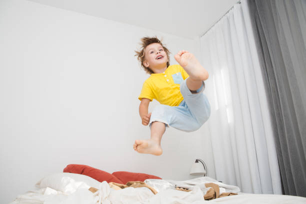 istock Cheerful little boy  jumping on bed at home 888157568