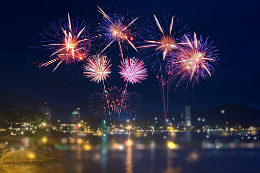 Colorful firework display over city on the beach.