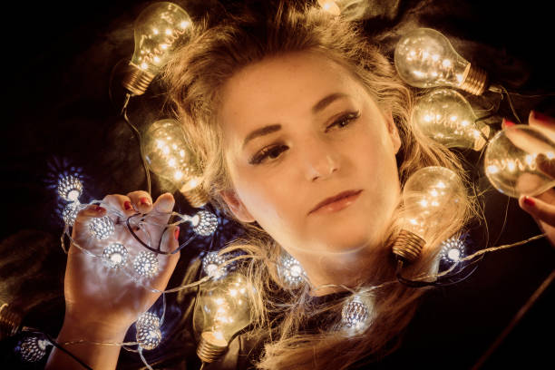 istock A young woman is surrounded by lights 888193430
