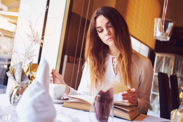 istock Brunette reading a book in a restaurant 888205168
