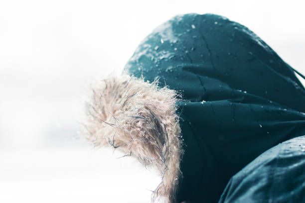 istock Male looking at down with a hood in a snowing day 888210630
