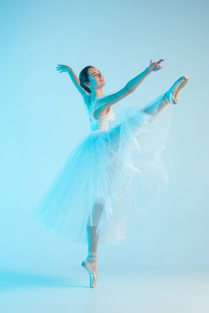 istock Young and incredibly beautiful ballerina is dancing in a blue studio 888215416