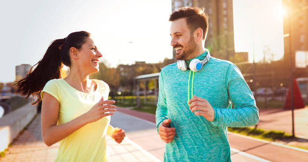 istock Young attractive couple running outside on sunny day 888215584