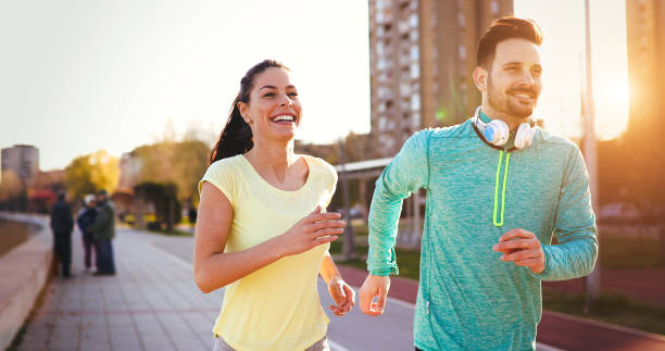 istock Young attractive couple running outside on sunny day 888215682
